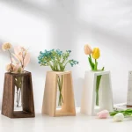 Vaso de madeira escura, em cerâmica branca e em cerâmica bege, cada um contendo flores artificiais coloridas, perfeitos para a decoração interior elegante.