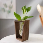 Vaso de madeira com uma planta verde de folhas largas, decoração natural e moderna para interior.