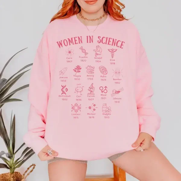 Sweatshirt rosa com motivos de mulheres na ciência, ilustrando o compromisso e a contribuição das mulheres no campo científico. Perfeito para um visual descontraído e engajado.
