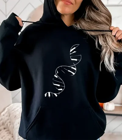 Uma mulher usa um sweatshirt com capuz preto com um padrão de dupla hélice de ADN branco, ilustrando a ciência e a genética em um estilo casual.