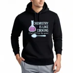 Sweat com capuz científico com inscrição "Chemistry is like cooking" e ilustração de frasco de laboratório e colher, perfeito para os amantes de ciência.