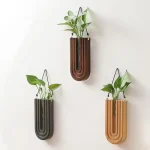 Três vasos de madeira suspensos com plantas verdes, decoração moderna e natural para interiores.